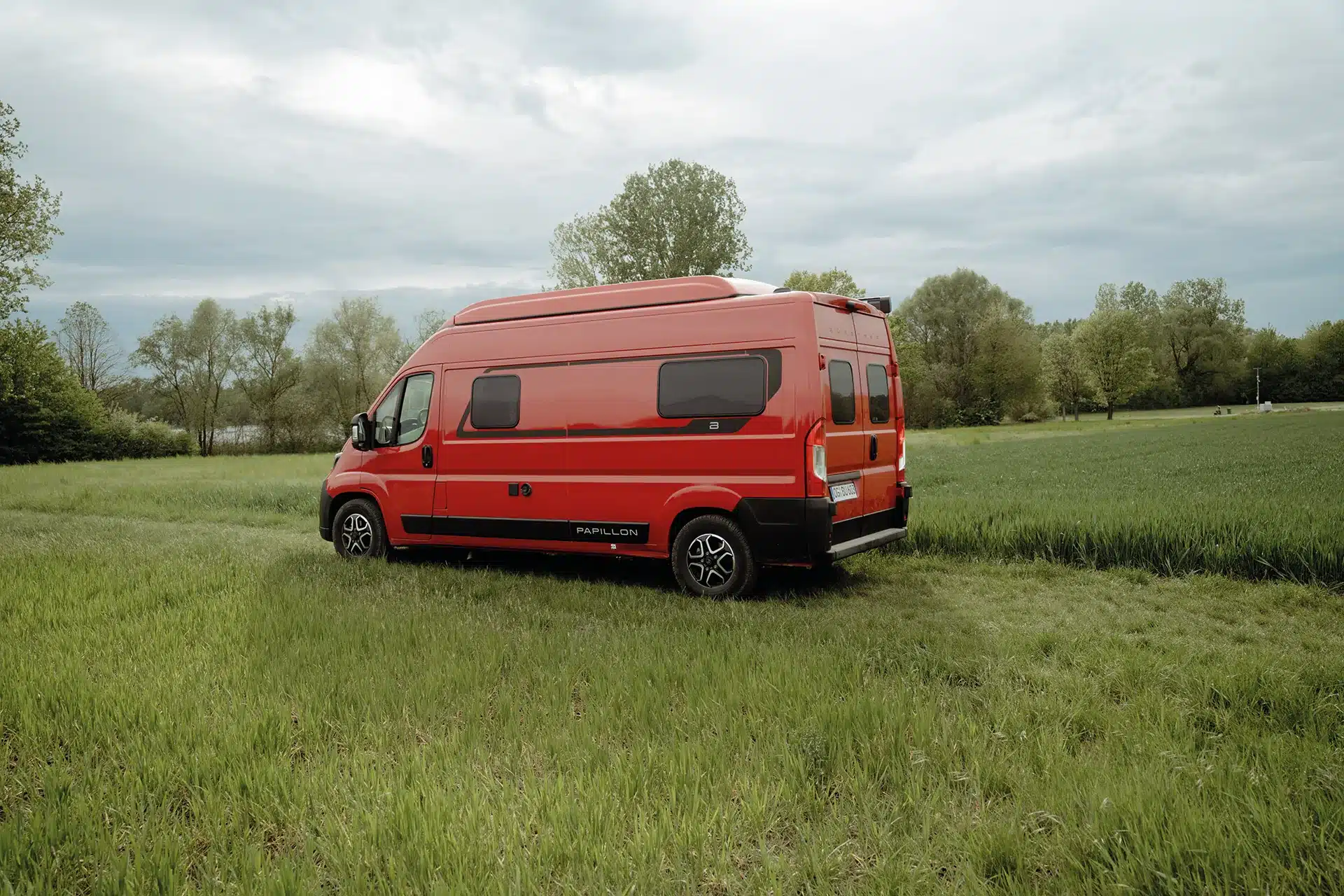 Bürstner Papillon PC 6.0 in Tizianrot auf einer Wiese