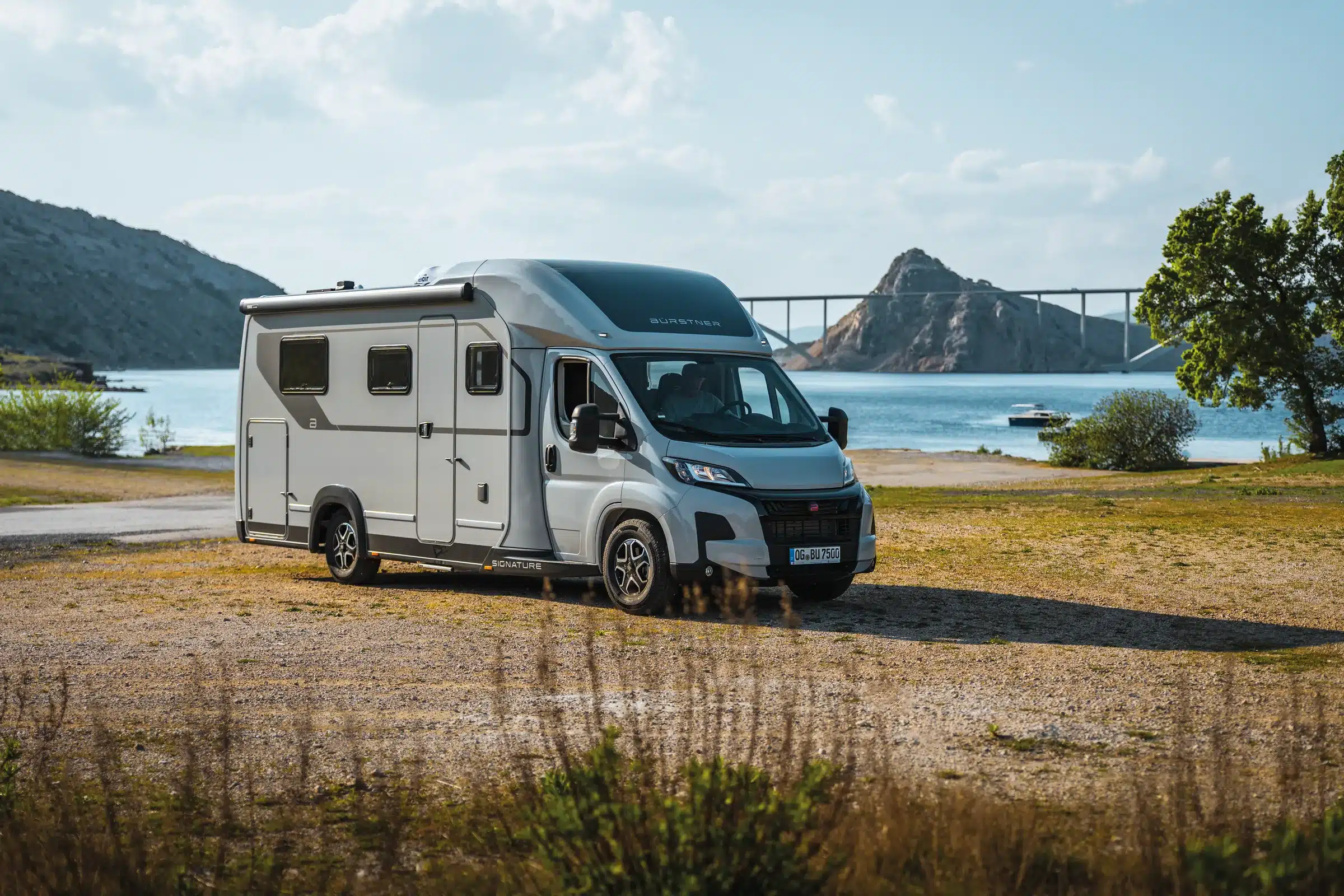 Bürstner Signature SFT 7.5 in Expeditiongrey an einer Bucht mit Brücke